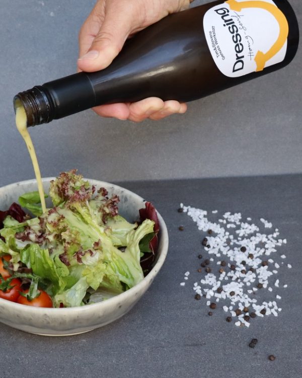 Das Honig-Senf-Dressing wird zu einem leckeren Salat gegeben