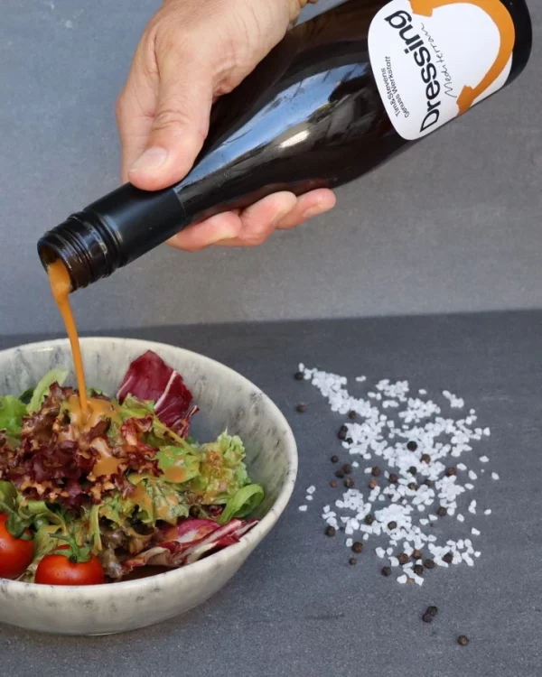 Das Mediterran-Dressing wird zu einem leckeren Salat gegeben